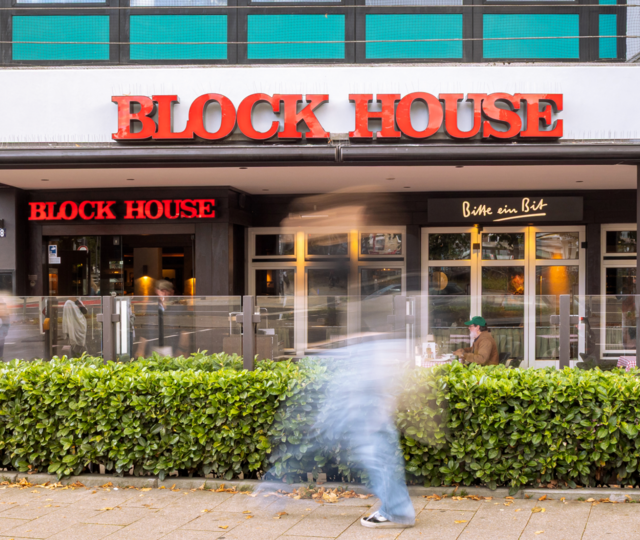 Frontalansicht des BLOCK HOUSE Hamburg Wandsbek mit Terrasse und Eingangsbereich