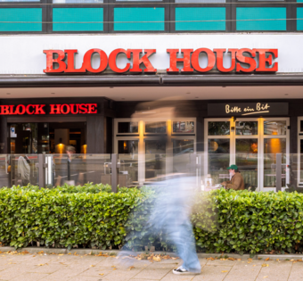 Frontalansicht des BLOCK HOUSE Hamburg Wandsbek mit Terrasse und Eingangsbereich