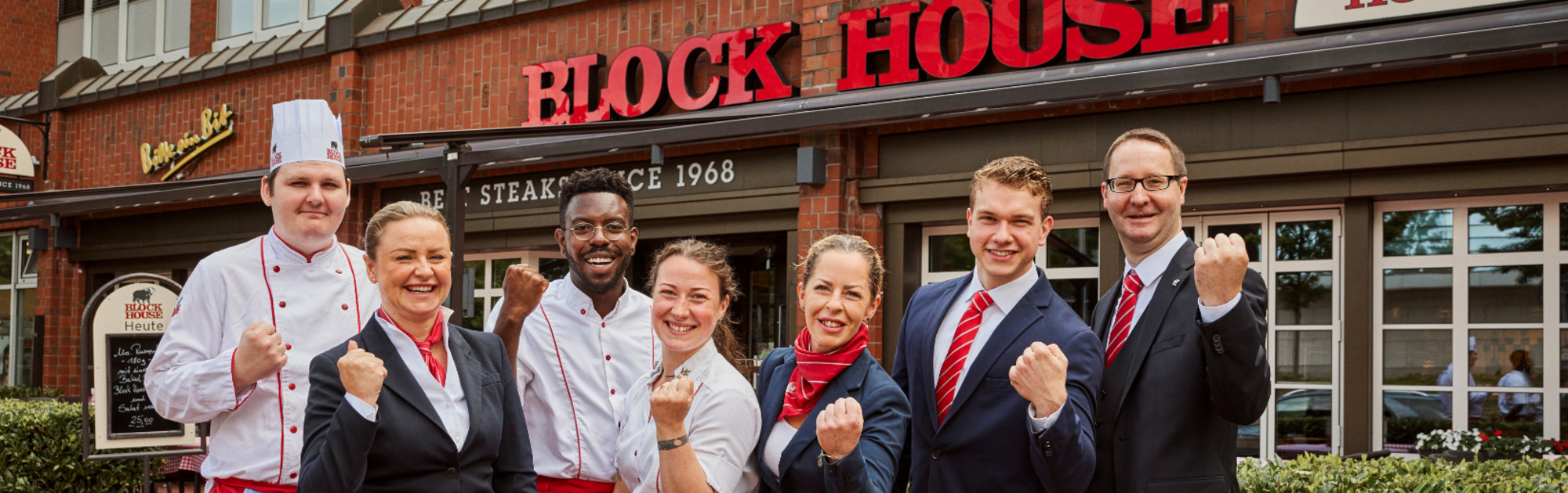 Mitarbeitende aus Küche und Service vor einem BLOCK HOUSE Restaurant