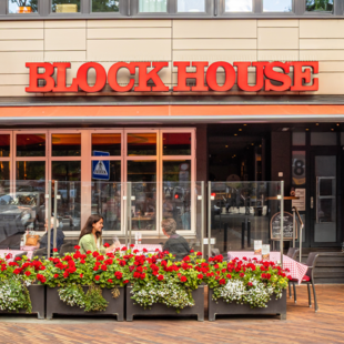 Außenansicht des BLOCK HOUSE Steakhouse in Hamburg Harburg mit Terrasse und Gästen im Außenbereich