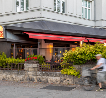 Terrasse des BLOCK HOUSE Berlin Theodor-Heuss-Platz mit Tischen und Gästen vor dem Steakhouse