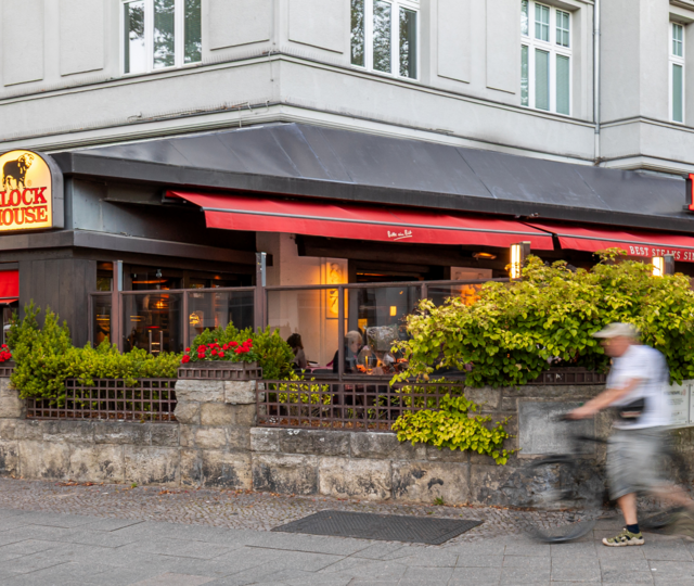Terrasse des BLOCK HOUSE Berlin Theodor-Heuss-Platz mit Tischen und Gästen vor dem Steakhouse