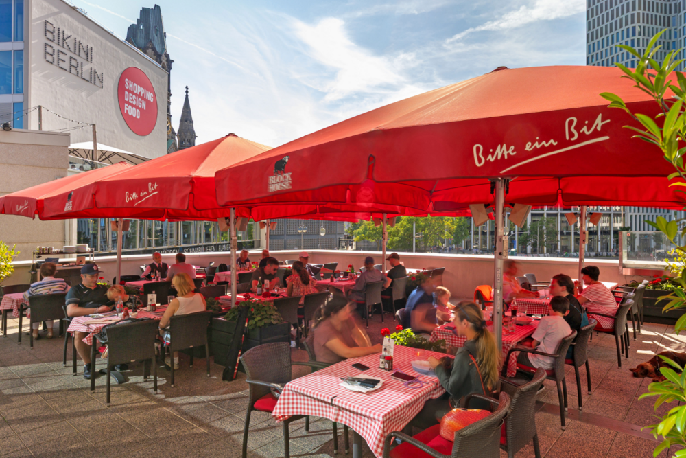 Terrasse mit Sonnenschirmen des BLOCK HOUSE Restaurants am Zoo Palast in Berlin 